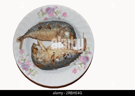 Two deep-fried mackerels are placed alternately, heads and tails on a plate. Stock Photo
