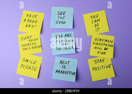 Paper notes with life-affirming phrases on violet background Stock Photo
