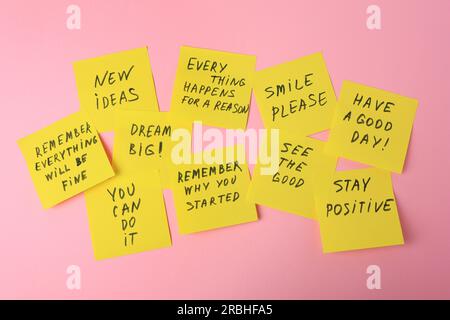Paper notes with life-affirming phrases on pink background Stock Photo