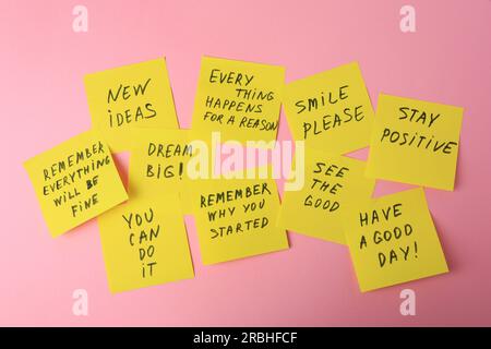 Paper notes with life-affirming phrases on pink background Stock Photo