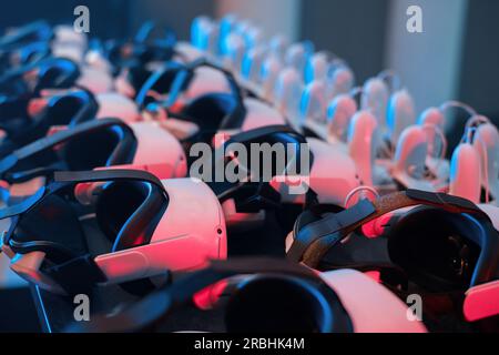 Virtual reality VR equipment on a table. VR headsets and joysticks. Neon lights Stock Photo