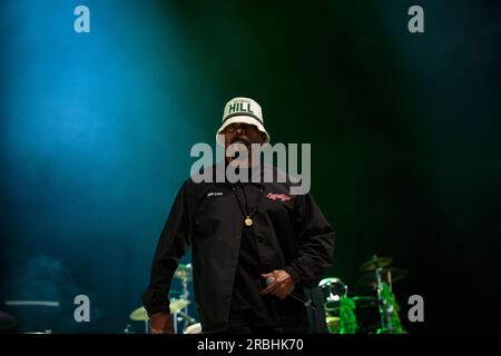 Sen Dog of Cypress Hill performs on stage sporting a bucket hat, a black tracksuit, and holding a microphone. Stock Photo