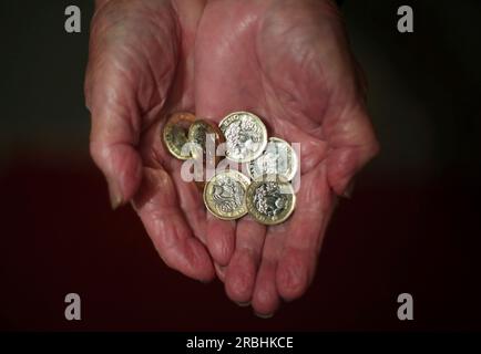 File photo dated 21/12/17 of an elderly woman holding pound coins in her hands in Poole, Dorset. Almost half of women aged between 50 and 65 plan to continue working after they reach state pension age, new research by Rest Less suggests. A study of official statistics found that almost one in two older women planned to either stay in work on their existing hours or reduced hours. Issue date: Monday July 10, 2023. Stock Photo