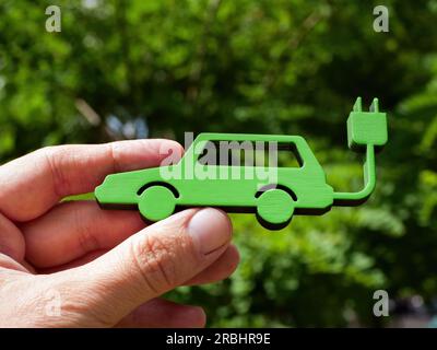 Close up of hand holding model of electric car. Stock Photo