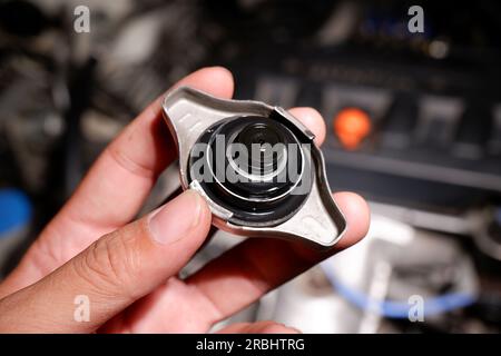 Mechanic hand holding car radiator cap, inside of radiator cap, Automotive parts concept. Stock Photo