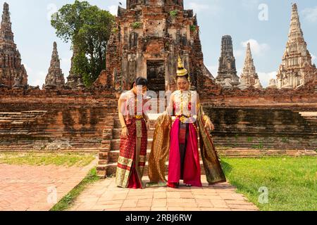 Thai girls in traditional Thai costume with red umbrella in Thai temple, identity culture of Thailand. Ayutthaya, Thailand May 30, 2023 Stock Photo