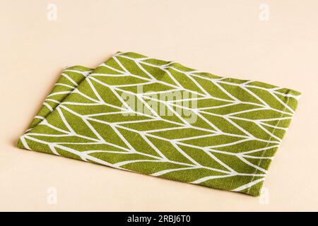 top view with green kitchen napkin isolated on table background. Folded cloth for mockup with copy space, Flat lay. Minimal style. Stock Photo