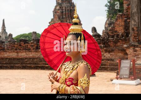 asian woman wearing thai traditional suit stand with umbrella against old temple in ayutthaya world heritage of unesco thailand. Ayutthaya, Thailand M Stock Photo