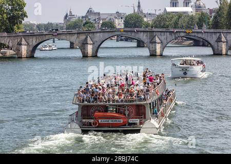 Romantic Paris. People on Bateaux Mouches river cruise boats on River Seine near Pont Royal. Paris Stock Photo