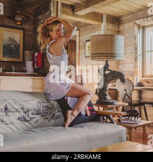 Pretty woman posing on sofa in cabin Stock Photo
