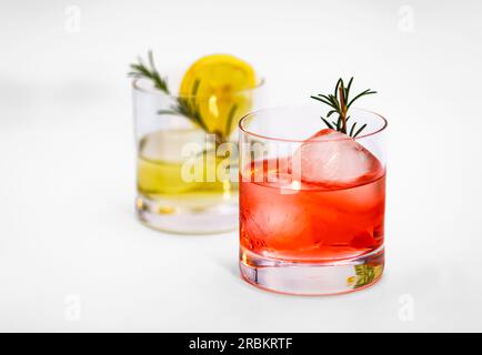 Red cocktail with decoration in a tumbler glass with ice cubes isolated against a white background as a studio shot Stock Photo