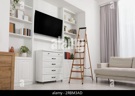 Wooden folding ladder in stylish living room Stock Photo