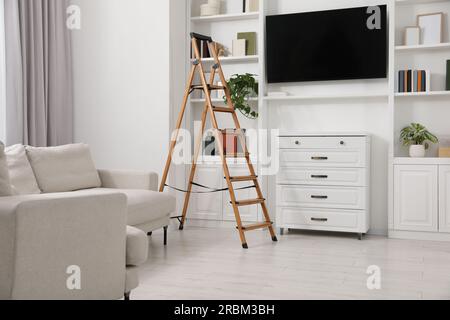 Wooden folding ladder in stylish living room Stock Photo