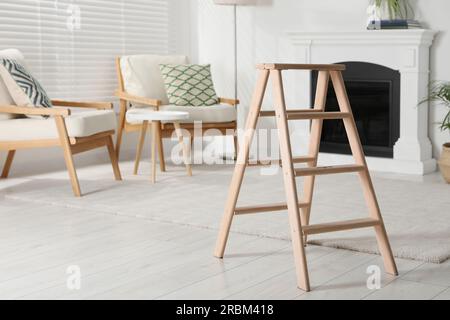 Wooden folding ladder in stylish living room Stock Photo