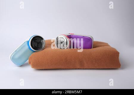 Different fabric shavers and woolen cloth with lint on white background Stock Photo