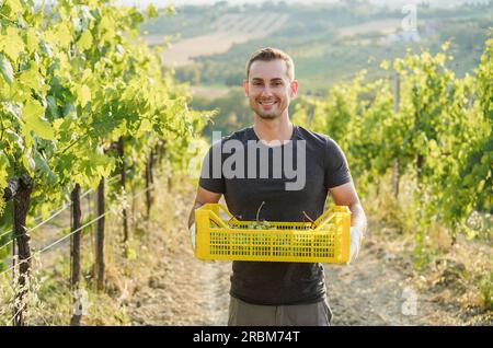 Senior wine producer man smiling in front of camera with vineyard in background - Organic farm and small business concept - Focus on face Stock Photo