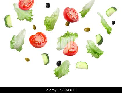 Lettuce leaves, olives, cut cucumber and tomatoes falling on white background Stock Photo