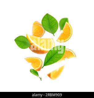 Juicy orange slices and green leaves flying on white background Stock Photo