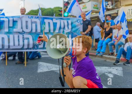 Haifa, Israel - July 08, 2023: People marching with flags and various signs. Week 27 of anti-government protest in Haifa, Israel Stock Photo