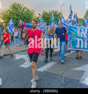 Haifa, Israel - July 08, 2023: People marching with flags and various signs. Week 27 of anti-government protest in Haifa, Israel Stock Photo