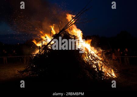 A crowd watches flames and embers dancing from a beacon set alight in celebration of the Diamond Jubilee of Her Majesty Queen Elizabeth II in 2012 Stock Photo