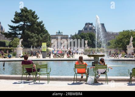 Jardin des Tuileries. People sit by fountain by Grand Bassin Rond on hot, sunny day in 17th century, Tuileries Gardens, Place de la Concorde, Paris Stock Photo