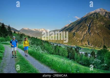Man and woman hiking on hiking trail from Landeck to Kronburg, Starkenberger Weg, Ötztal Alps, Tyrol, Austria Stock Photo