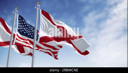 The state flags of Alabama waving with the national flag of the United States of America on a clear day. Three flags, with the one in the center being Stock Photo