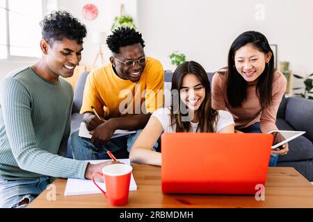 Young group of student friends studying together with computer at home Stock Photo
