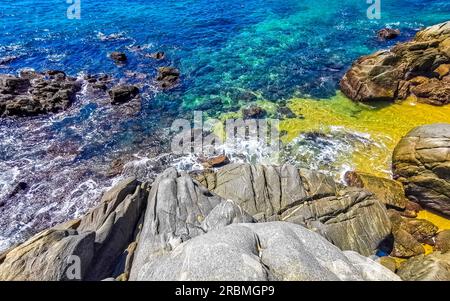 Beach sand turquoise blue water rocks cliffs boulders palm trees huge big surfer waves and panorama view on the beach Playa Manzanillo and Puerto Ange Stock Photo