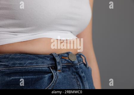 Foto de Woman wearing tight clothes on light grey background, closeup view  with space for text. Overweight problem do Stock