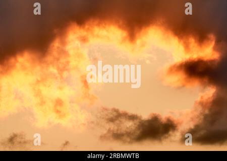 Dramatic summer sky with fiery clouds in orange yellow at sunset. Beautiful natural scenery. Dubnica, Slovakia Stock Photo