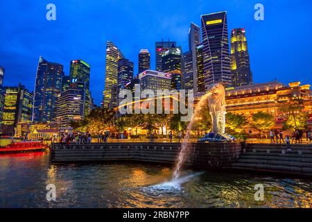 Singapore - April 27, 2018: the Merlion Statue with Central Business district or CBD Buildings and Fullerton Hotel on background. Marina Bay downtown Stock Photo