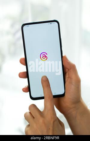 Kyiv, Ukraine - July. 8th, 2023: Threads logo on the phone screen in hand. Using the social network application. Stock Photo
