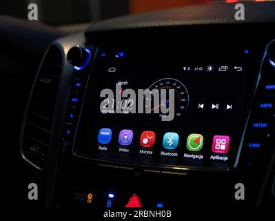 Modern car interior dashboard touch display closeup, Android auto touchscreen monitor panel inside the vehicle at night, detail shot up close, lit up. Stock Photo