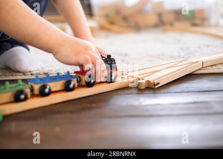 Close-up of children's hands playing with trains. The kid spends time playing.  Stock Photo