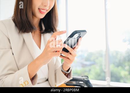Happy woman talking and chatting online with friends on smartphone, Businesswoman using mobile phone at office, Female officer worker relaxing with Stock Photo