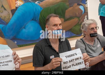 Members of Extinction Rebellion NYC and Rise and Resist with strips of tape on the mouth, on which they had written words such as 'Earth', 'glaciers' and 'famine' hold signs reading 'No art on a dead planet' pose for photos during a solidarity protest. Extinction Rebellion NYC and Rise and Resist stage a protest calling to drop charges against Joanna Smith and Tim Martin in front of the Metropolitan Museum of Art in New York City. Joanna Smith and Tim Martin smeared paint on the case of a Degas sculpture during an act of civil disobedience at National Gallery of Art in Washington, DC. Stock Photo