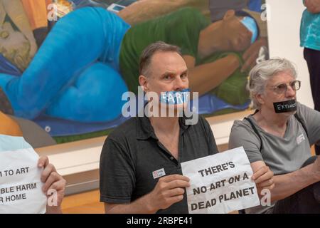 New York, USA. 8th July, 2023. Members of Extinction Rebellion NYC and Rise and Resist with strips of tape on the mouth, on which they had written words such as ''Earth'', ''glaciers'' and ''famine'' hold signs reading ''No art on a dead planet'' pose for photos during a solidarity protest. Extinction Rebellion NYC and Rise and Resist stage a protest calling to drop charges against Joanna Smith and Tim Martin in front of the Metropolitan Museum of Art in New York City. Joanna Smith and Tim Martin smeared paint on the case of a Degas sculpture during an act of civil disobedience at Nati Stock Photo