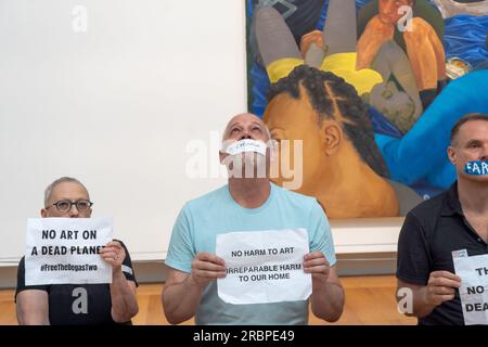 New York, USA. 8th July, 2023. Members of Extinction Rebellion NYC and Rise and Resist with strips of tape on the mouth, on which they had written words such as ''Earth'', ''glaciers'' and ''famine'' hold signs reading ''No art on a dead planet'' pose for photos during a solidarity protest. Extinction Rebellion NYC and Rise and Resist stage a protest calling to drop charges against Joanna Smith and Tim Martin in front of the Metropolitan Museum of Art in New York City. Joanna Smith and Tim Martin smeared paint on the case of a Degas sculpture during an act of civil disobedience at Nati Stock Photo