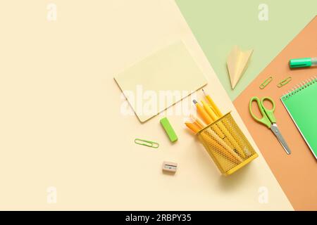 Composition with notebooks and different school stationery on color background Stock Photo