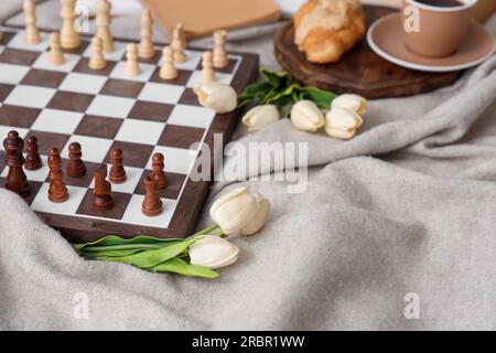 Chess board with tulips on plaid, closeup Stock Photo