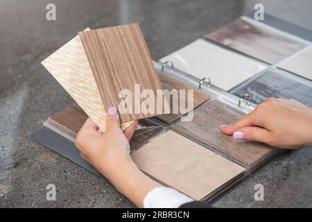 Catalog with samples of different types of wood. The process of selecting materials for home renovation, services of a designer or architect. Stock Photo