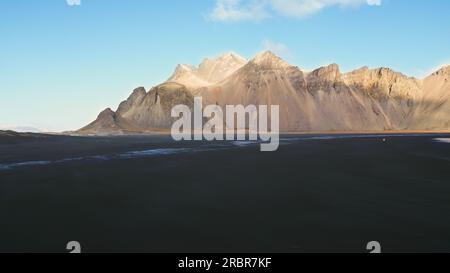 Aerial view of stokksnes sand beach in icelandic scenery, majestic vestrahorn mountains in arctic landscape. Spectacular iceland panoramic view with atlantic ocean shore, coastline. Slow motion. Stock Photo