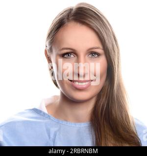 Portrait of a young and friendly female specialist practitioner looking at camera, with blue eyes and a beautiful smile, while wearing blue medical Stock Photo