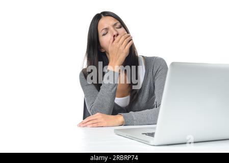 Tired young businesswoman yawning after a long days work as she winds down ready to go home for the evening, on white Stock Photo
