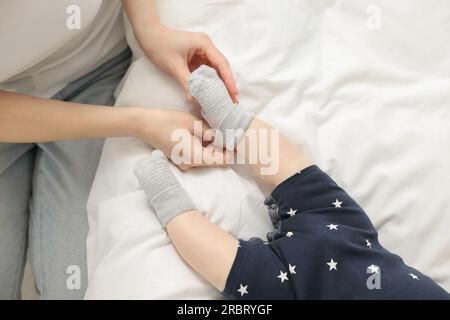 Mother putting socks on her baby, top view Stock Photo