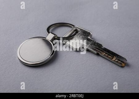 Key with metallic keychain on light grey background, closeup Stock Photo