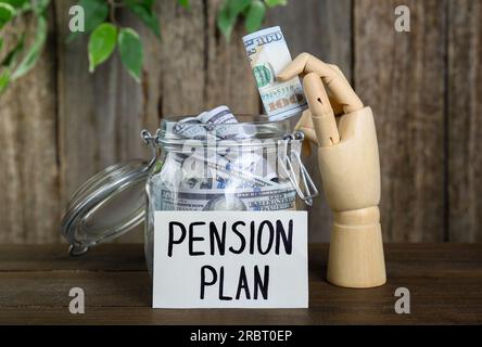 Card with phrase Pension Plan, mannequin hand and money in glass jar on wooden table. Retirement concept Stock Photo