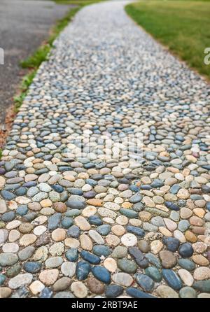 Natural stone walkways in the park. Stones path in garden.Polished stone gray pebble stone pavement. Textured Cobble Pavement, Reflexology. Pebble sto Stock Photo